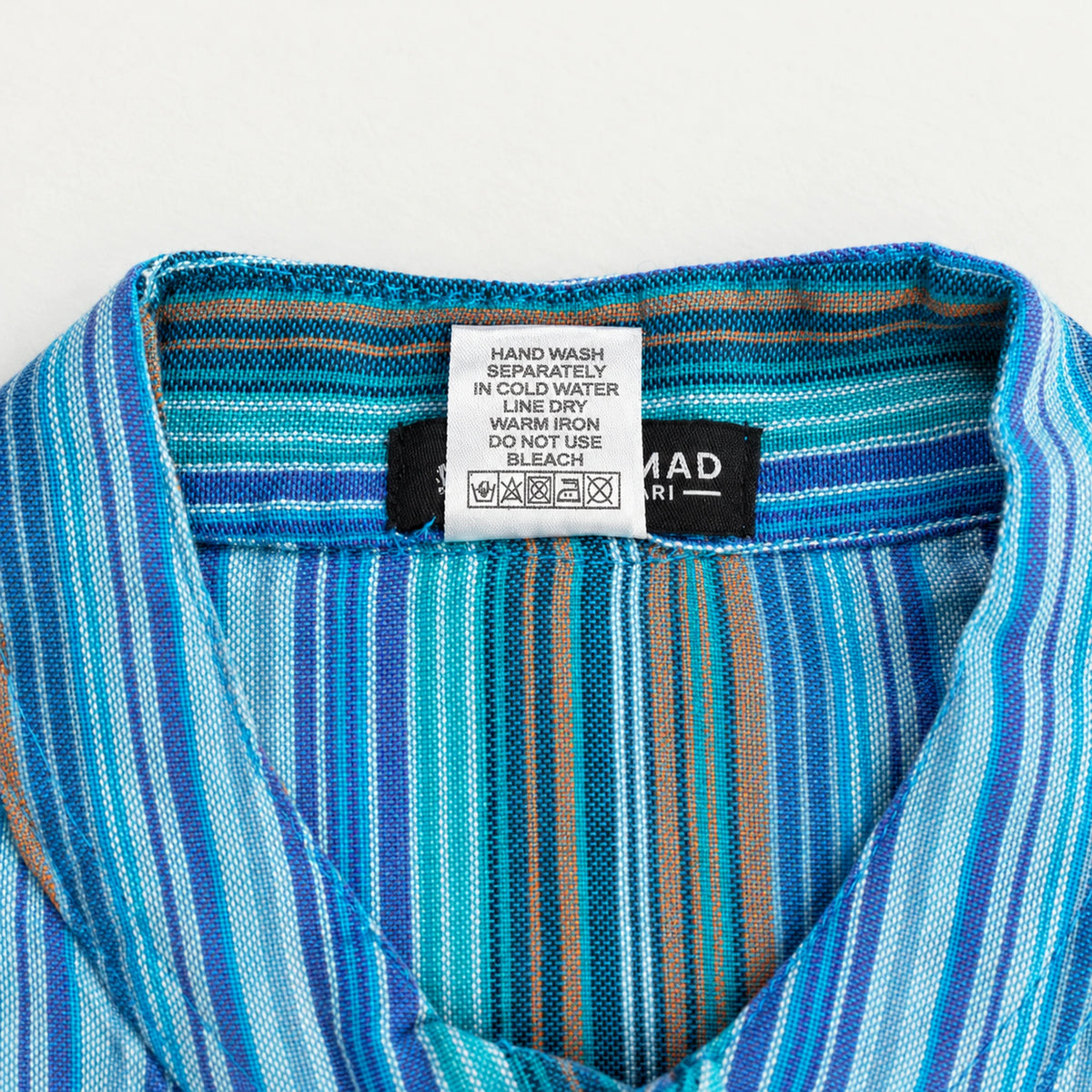 Care label inside the striped collar, with instructions to hand wash separately in cold water, line dry, warm iron and avoid bleach.