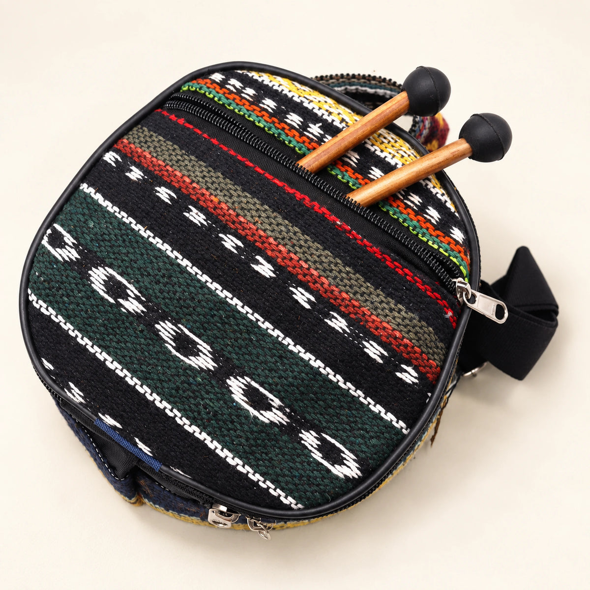 Dark patterned carry bag with zip closures and visible straps, with two mallets projecting from its outer pocket.