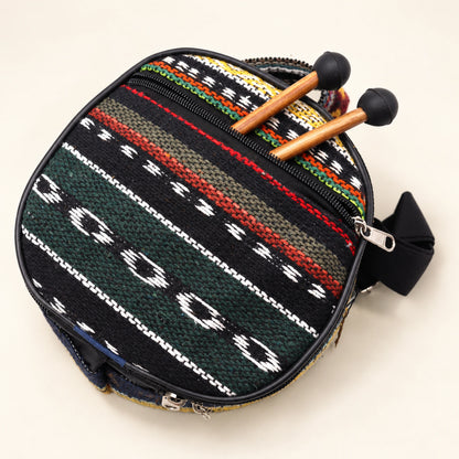 Dark patterned carry bag with zip closures and visible straps, with two mallets projecting from its outer pocket.