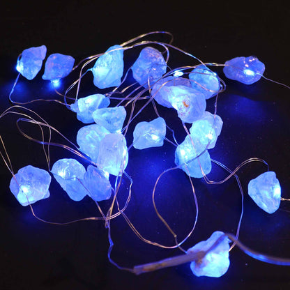 Celestit Ädelstensmagi Lights – Dekorativ ljusslinga med glödande blå celestitstenar på koppartråd, närbild mot mörk bakgrund