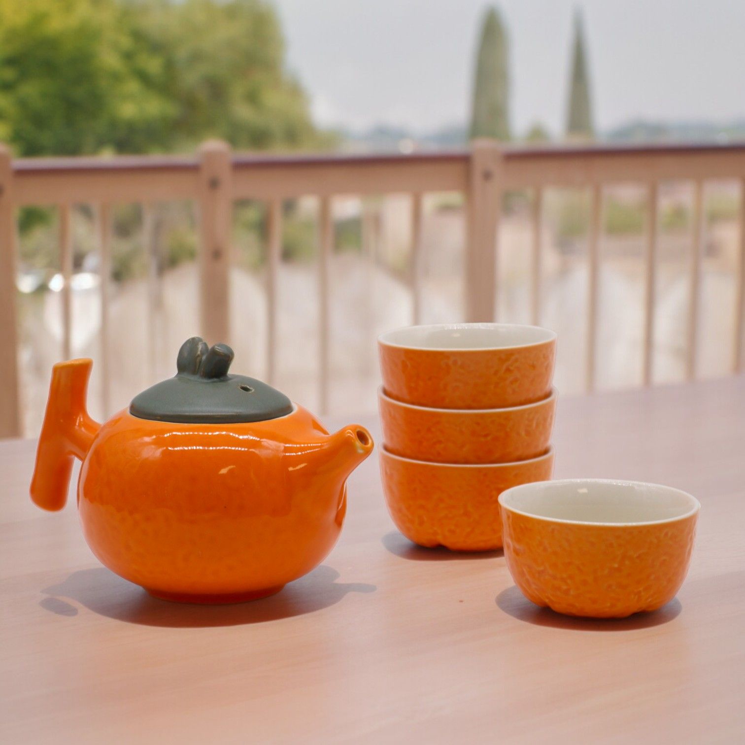 Ceramic Herbal Teapot Set – 200ML & 50ML Cups, tetera cerámica naranja con 4 tazas apilables sobre mesa