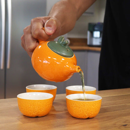 Ceramic Herbal Teapot Set – 200ML & 50ML Cups, tetera de cerámica naranja vertiendo té en cuatro tazas a juego