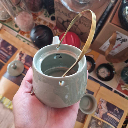 Ceramic Jade Teapot Set – 11x9x8 CM con acabado verde jade y asa dorada, vista superior del interior sostenido en la mano