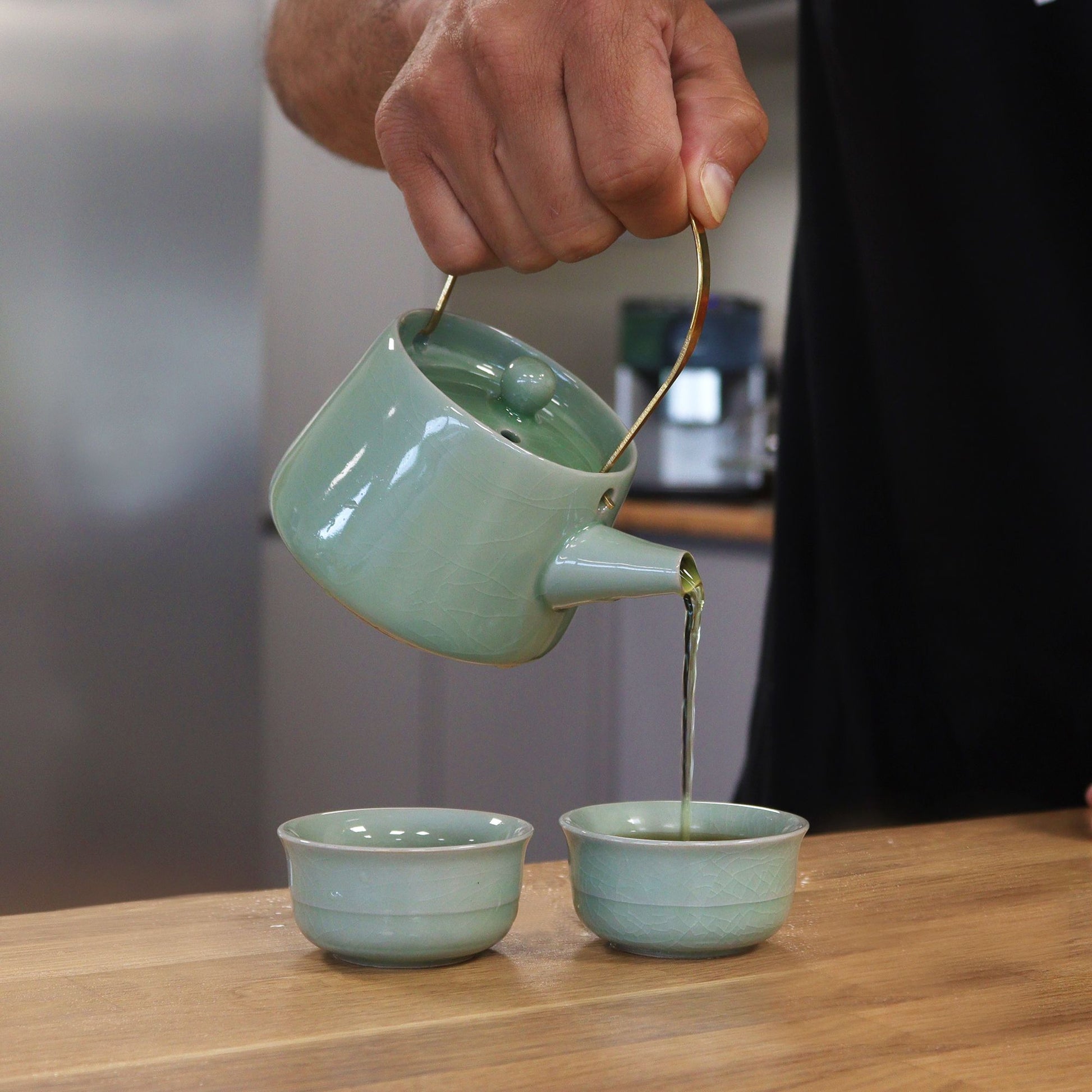 Ceramic Jade Teapot Set – 11x9x8 CM jade green ceramic teapot with gold-tone handle pouring tea into cups