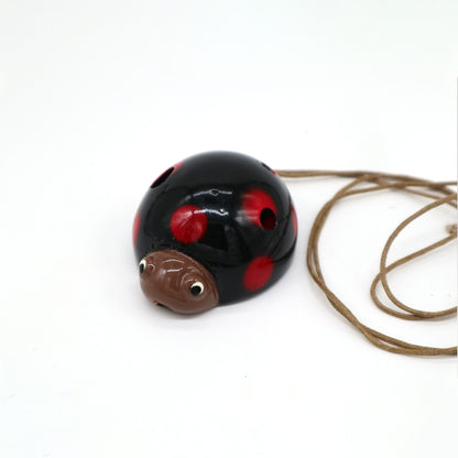 Ceramic Ocarina – Ladybird Design, glazed ceramic ladybird-shaped ocarina with red spots and neck cord on white background