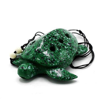 Alt Tag: Ceramic Turtle Ocarina – 10x9x4 CM, ocarina de cerámica con forma de tortuga verde moteada con cordón negro, vista superior