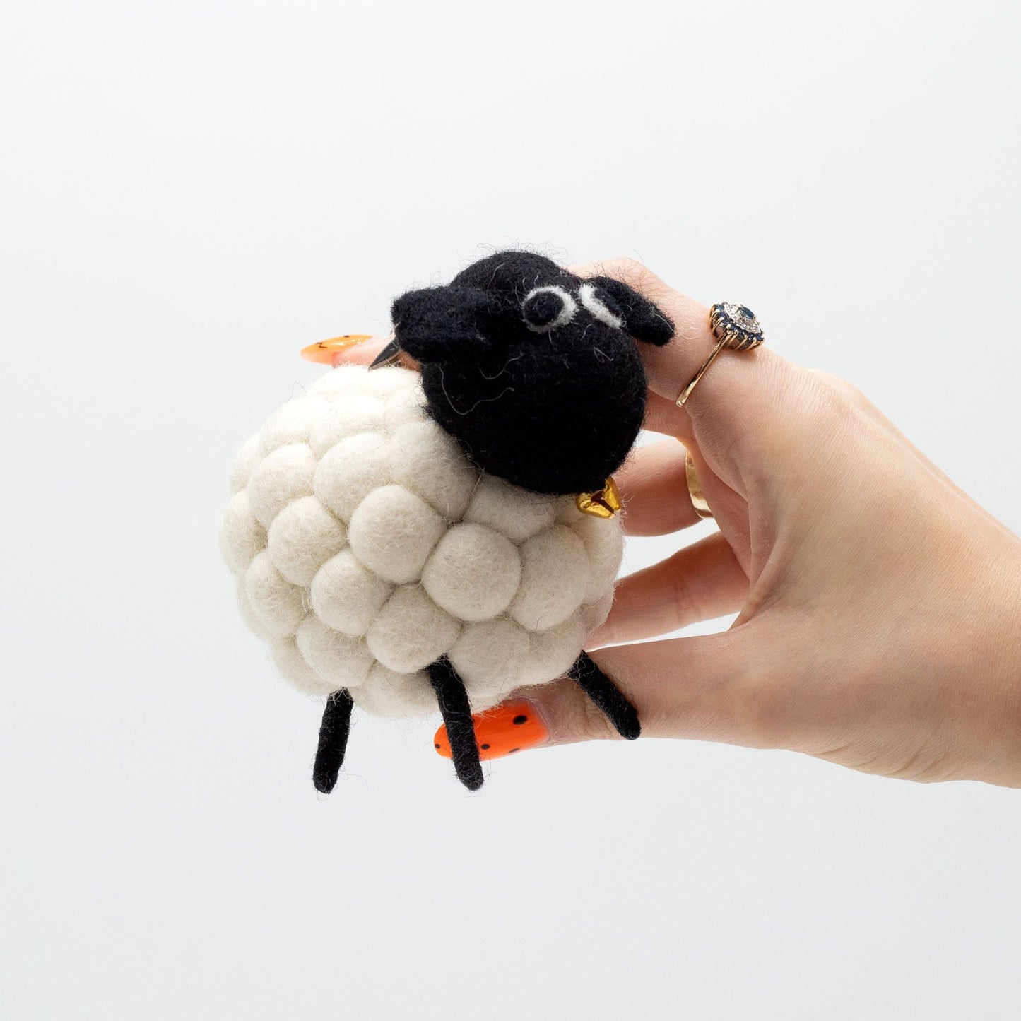 Alt Tag: Charming White Felt Sheep – 12x8x10 CM, oveja de fieltro blanca hecha a mano con cabeza negra, sostenida en una mano