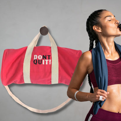 Cherry Pink Gym Bag – 100% Cotton with “DON’T QUIT!” print and beige straps, shown next to athlete with towel drinking water