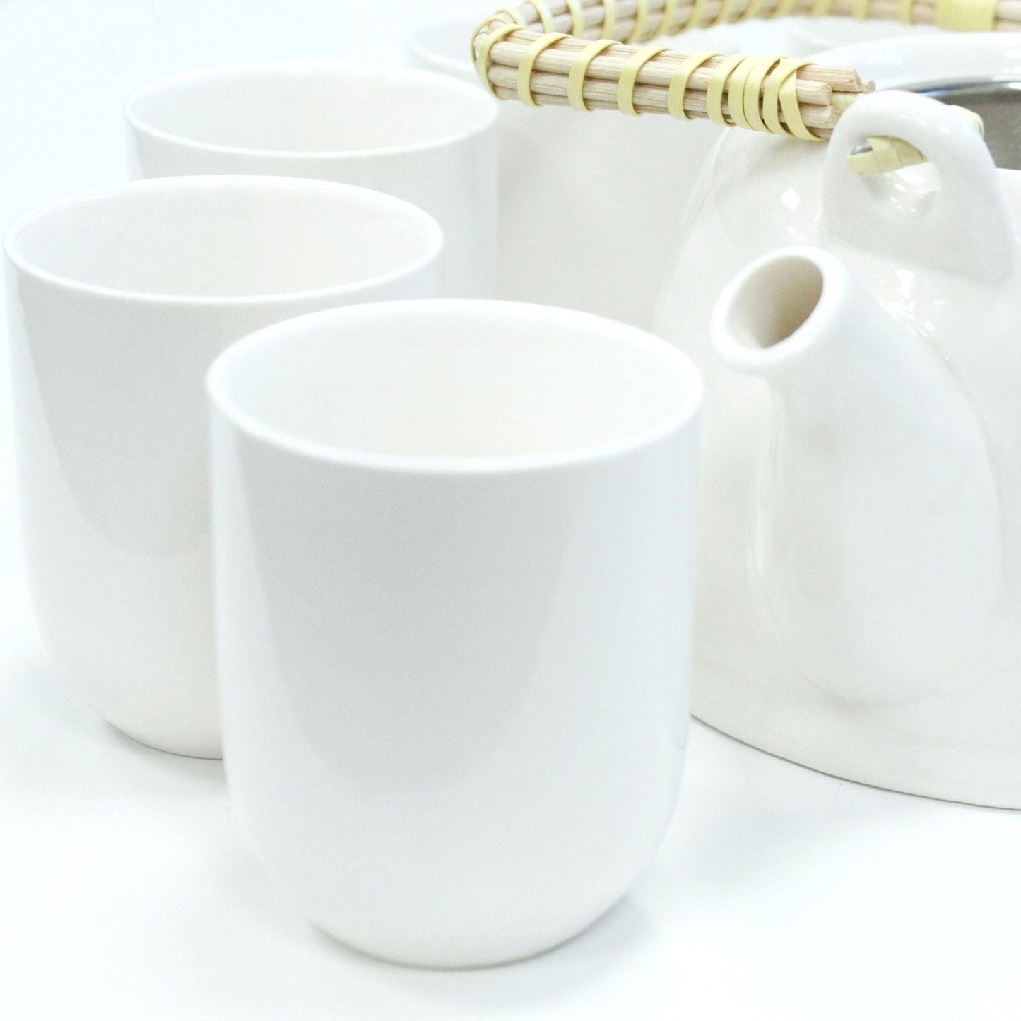 Alt Tag: Classic White Herbal Teapot Set – 850ML, 6 Cups con tetera de cerámica blanca y 3 tazas blancas en primer plano