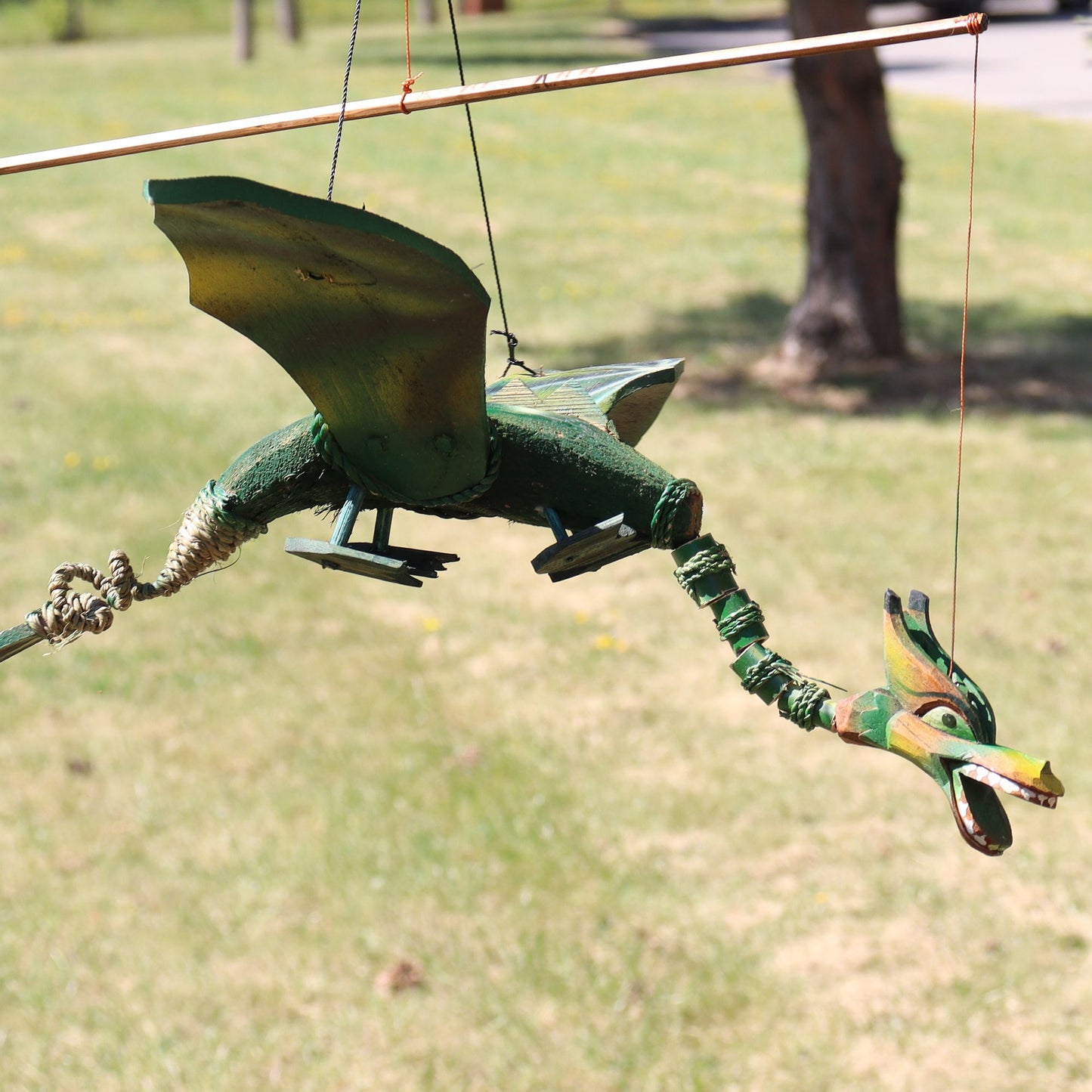Alt Tag: Coconut Dragon Mobile – 37CM handmade coconut dragon hanging mobile decoration in green, suspended outdoors