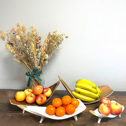 Fruktskålset i kokosblad – vitkalkad med bananer, äpplen och apelsiner på ett bord, handgjorda skålar i kokosblad med vitkalkad finish