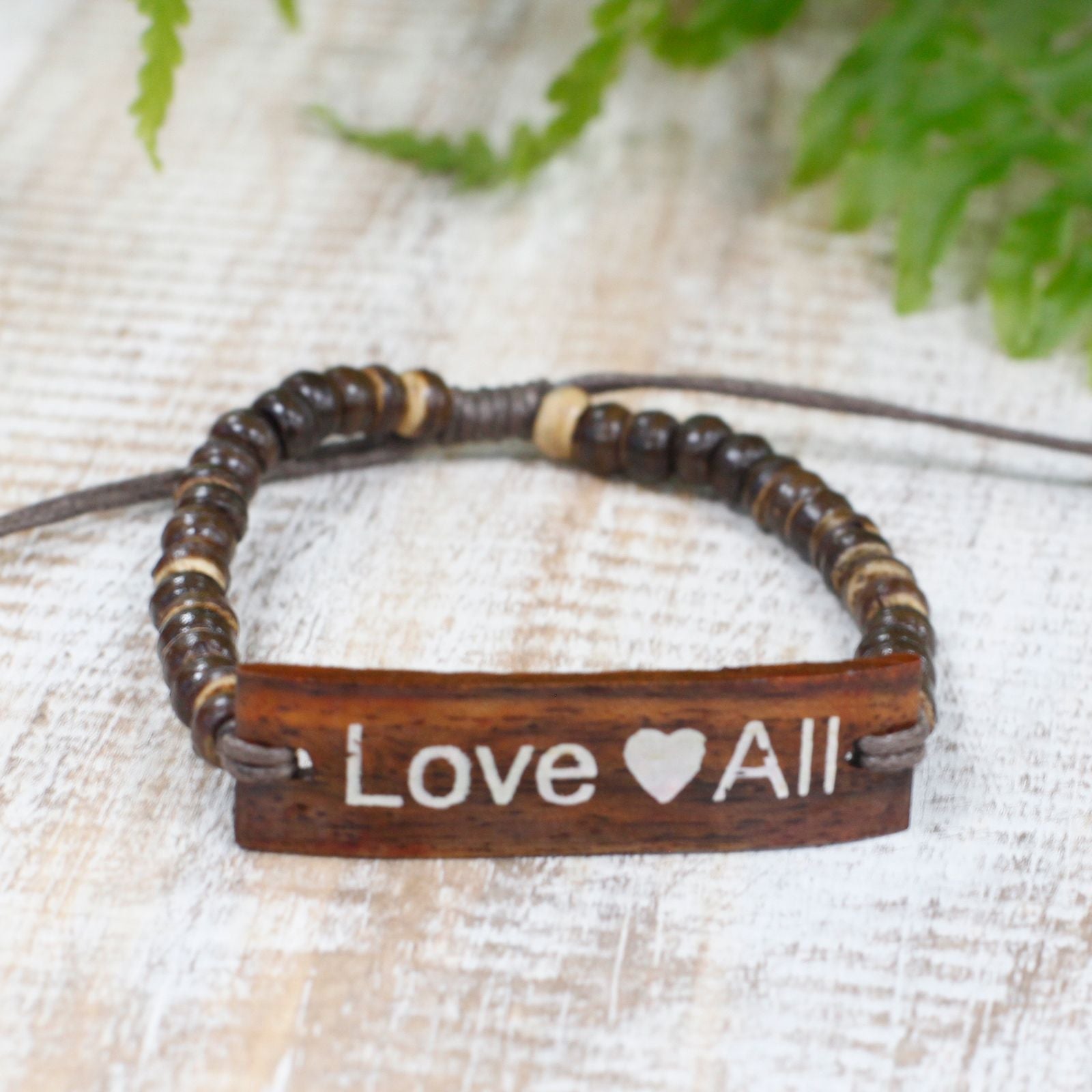 Alt Tag: Coconut Wood Bangle – LoveAll Slogan bracelet with adjustable cord and carved Love All text on natural coconut wood