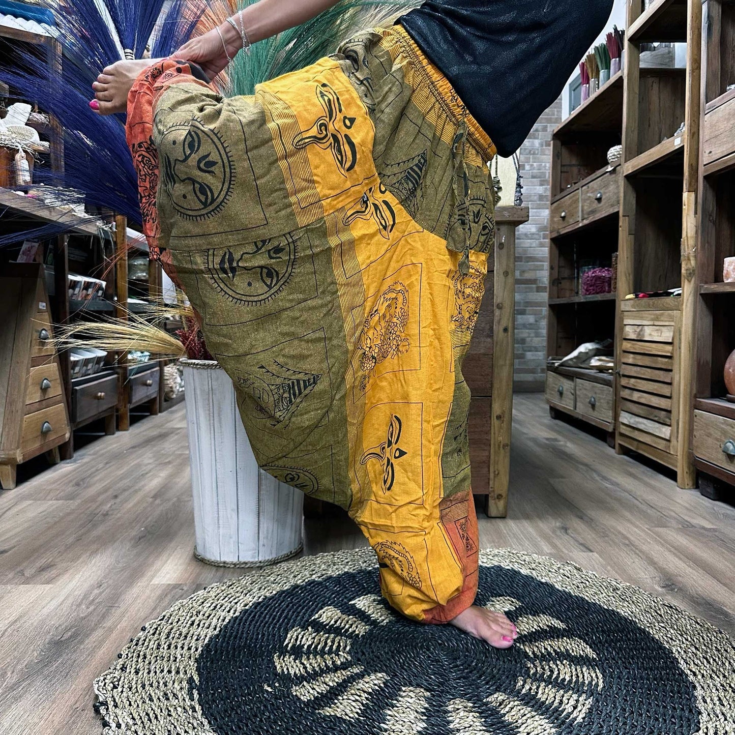 Alt Tag: Yoga-byxor i bomull, Aladdin – Himalayan Orange, burna i en yogaposition, avslappnad harem-passform med boho-tryckt bomullstyg