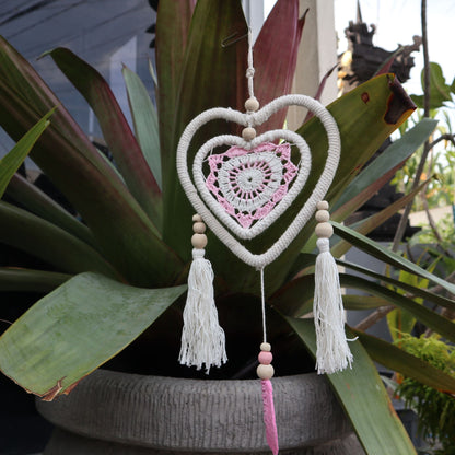 Cotton Dream Catcher – Medium Pink Heart handmade heart-in-heart cotton dreamcatcher with wooden beads and tassels hanging outdoors