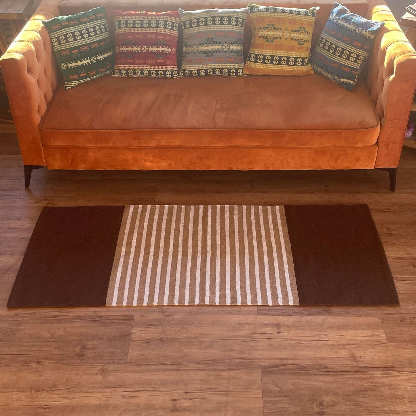 Alt Tag: Cotton Elegance-matta – 70x171 CM, mörkbrun/beige på trägolv framför soffa, randig beige mitt med mörkbruna ändar
