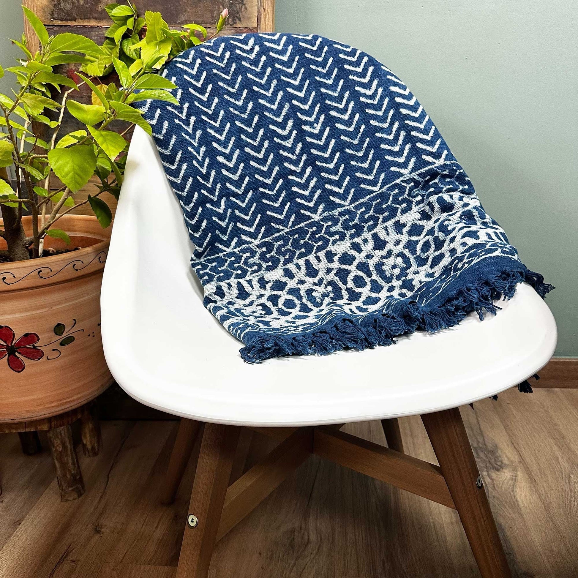 Cotton Handmade Indigo Throw – 170x120 CM draped on white chair, blue chevron pattern with tassel fringe