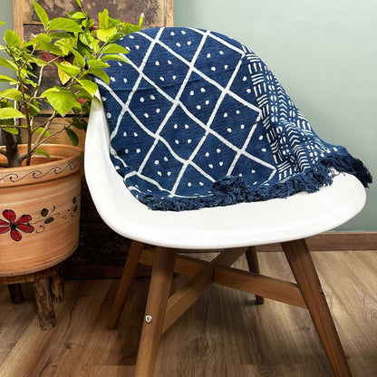 Alt Tag: Cotton Indigo Throw – 170x120 CM Midnight Heerak on white chair, hand-dyed indigo cotton throw with geometric pattern and fringes