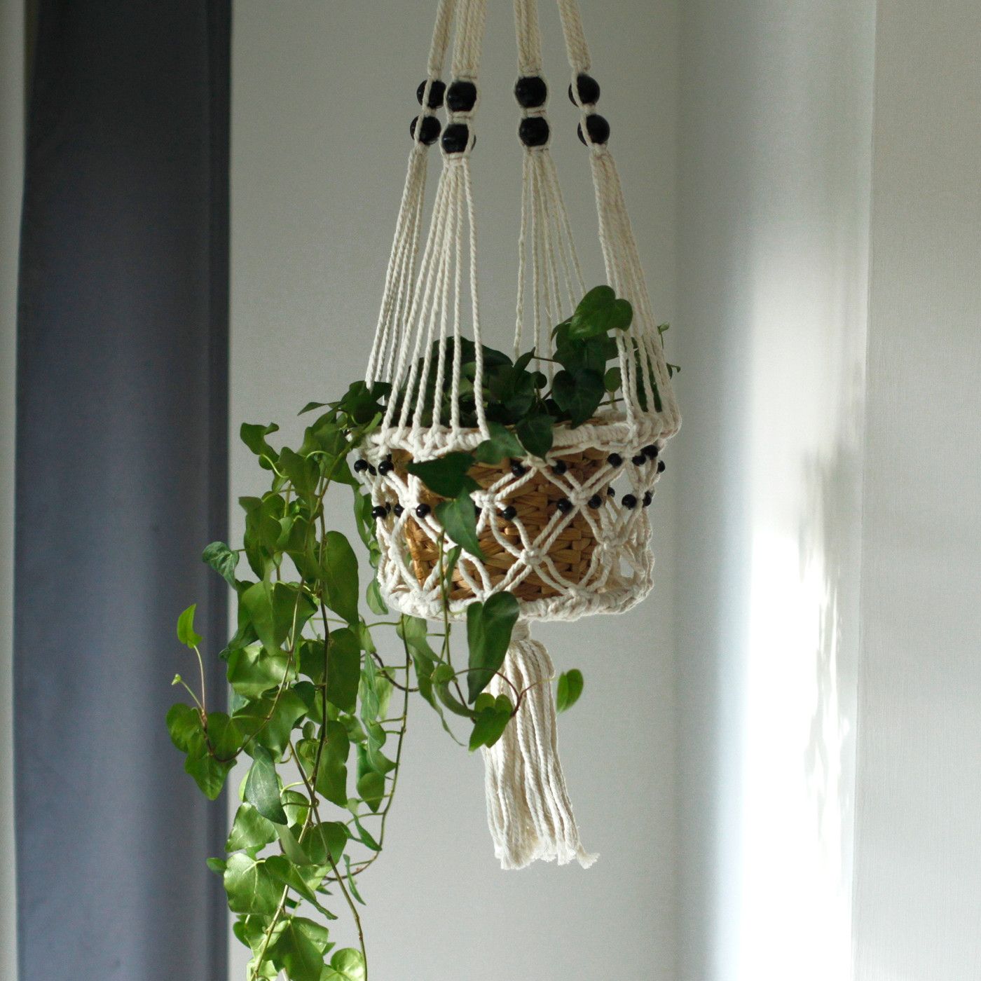 Cotton Macrame Pot Holder – Large Beaded holding a hanging plant pot with black beads and tassel, indoor wall display