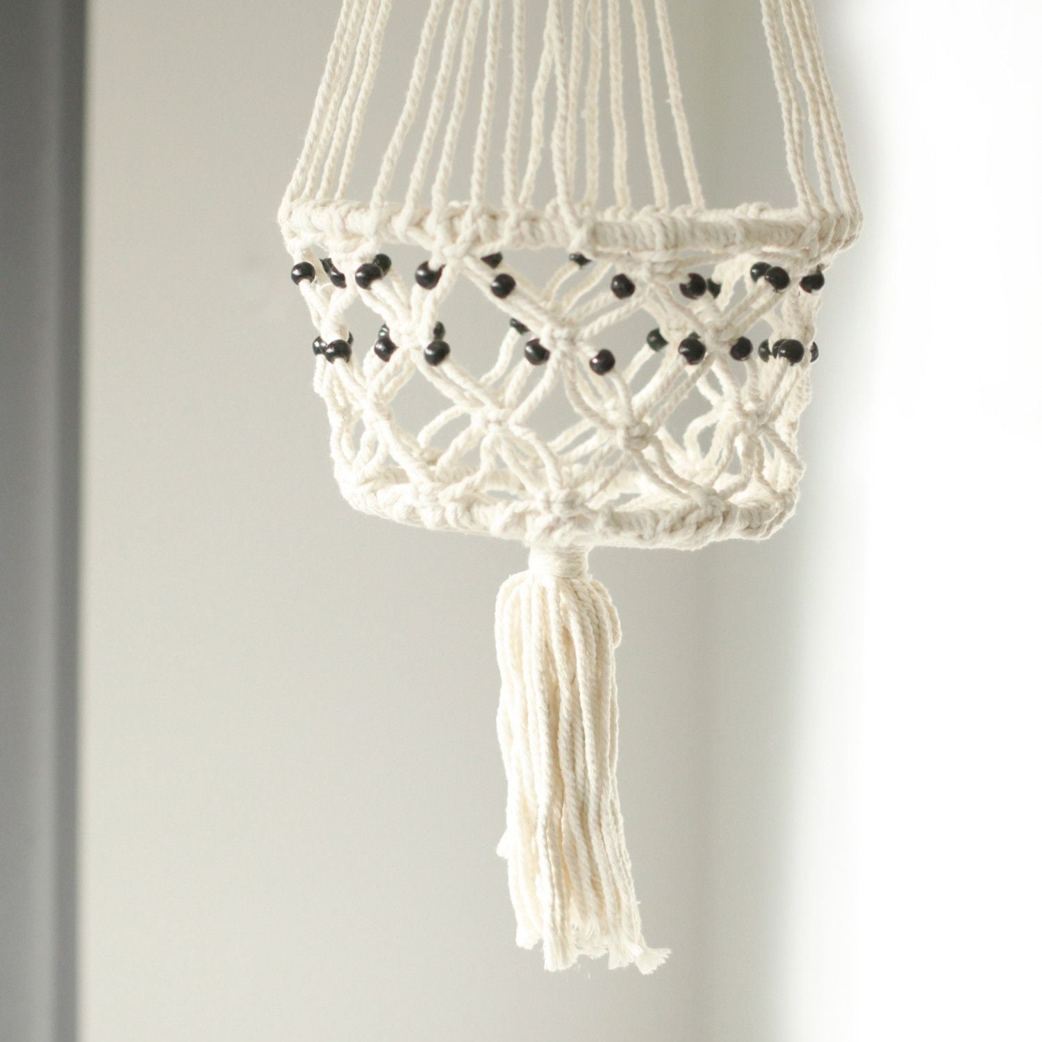 Alt Tag: Cotton Macrame Pot Holder – Large Beaded, white cotton hanging planter holder with black beads and tassel