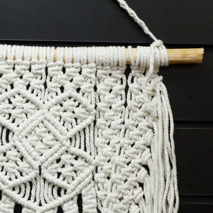 Alt-tagg: Väggbonad i macramé av bomull – 60x40 CM, närbild av vita macraméknutar i bomull på trästav, boho-väggdekor