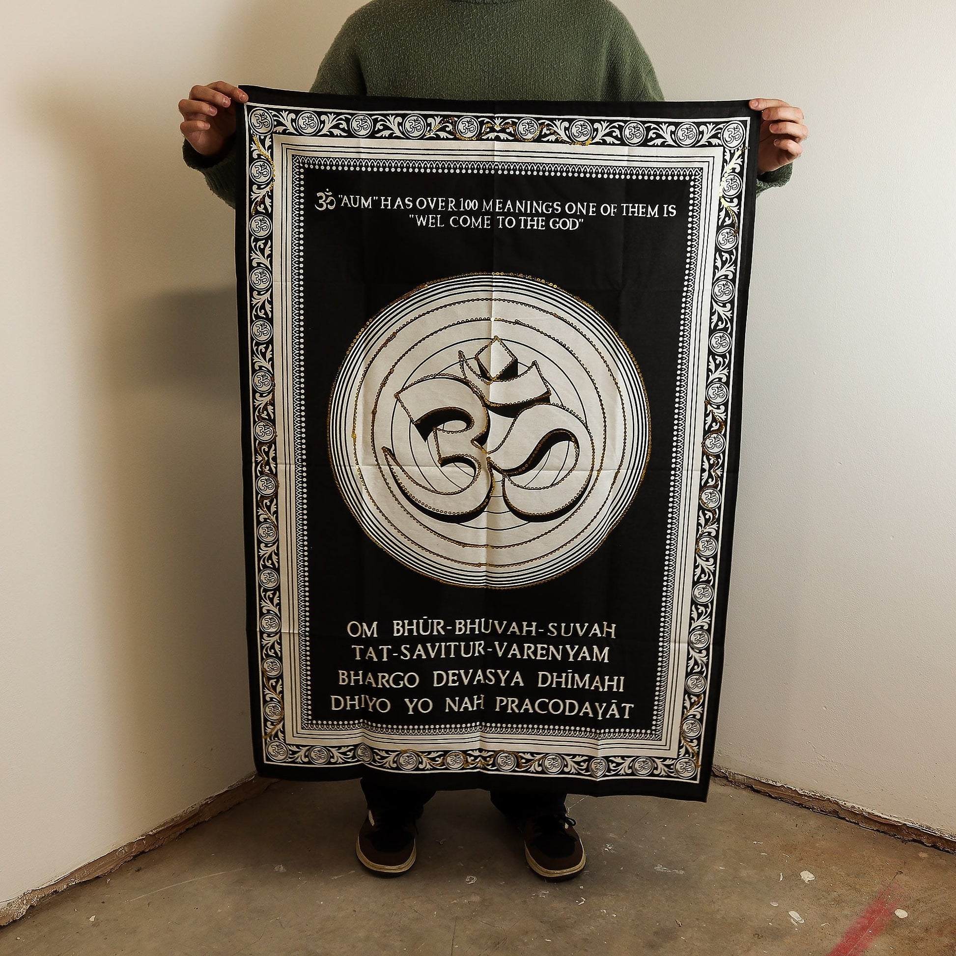 Alt Tag: Cotton Om Wall Art – 70x110 CM black cotton wall hanging with Om symbol and decorative border, shown held up for size