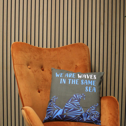 Alt Tag: Cotton Poem Cushion Cover – We Are Waves, Natural – 45x45 CM on orange armchair, gray cotton cover with “We are waves” quote
