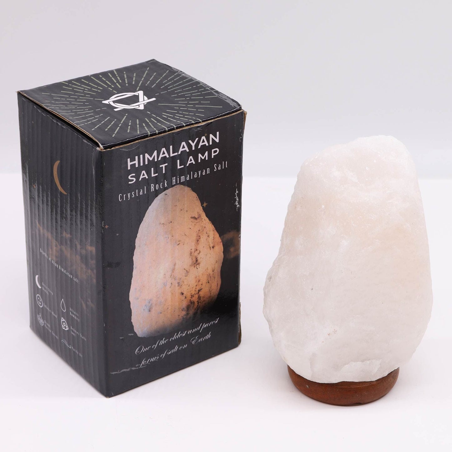 Crystal Rock Himalayan Salt Lamp with Base – Approx. 2–3 KG on wooden base beside Himalayan salt lamp retail box