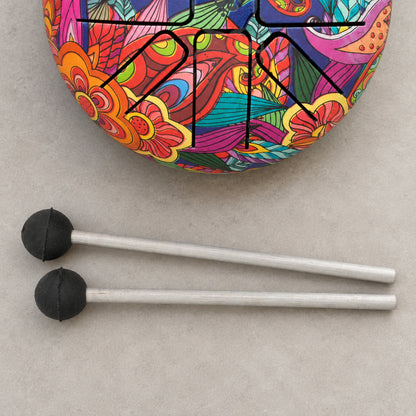 Two mallets with rounded black heads and pale shafts beside a cropped section of the colourful Happy Drum.