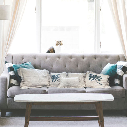 Elegant Cotton Fringe Cushion – 45x45 CM on grey sofa in bright living room with cat by window