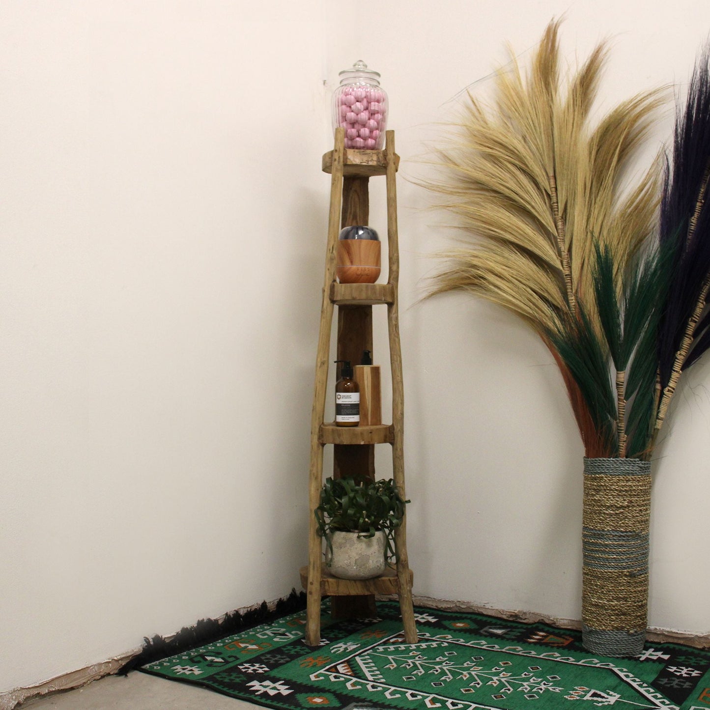 Elegant Teak Corner Shelves – 135CM Display in room corner, tall teak shelf holding decor items and plant on patterned rug