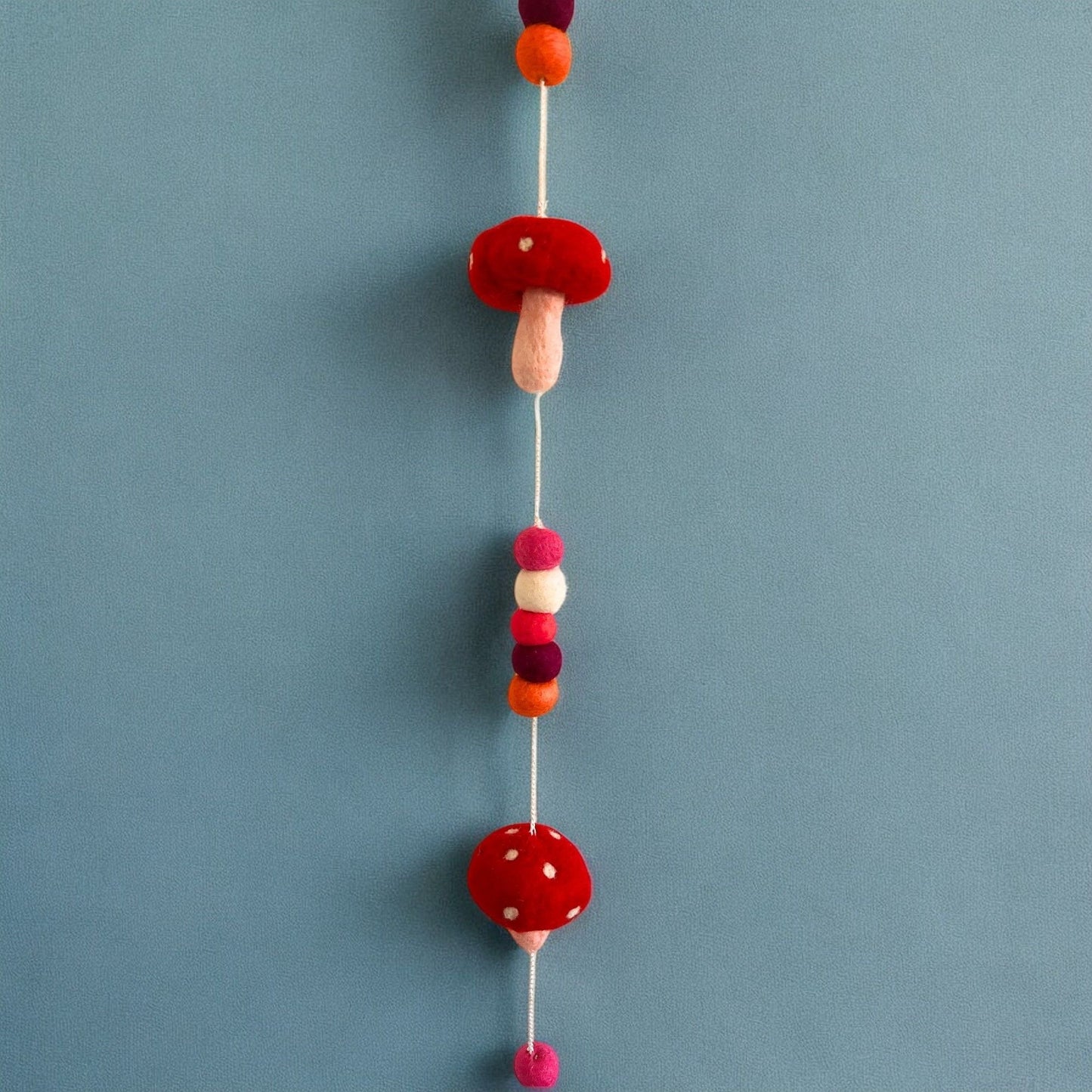 Alt Tag: Förtrollande väggbonad i filt – Redtop Mushrooms 110 CM med röda och vita filtsvampar och färgglada pom-poms på upphängningssnöre