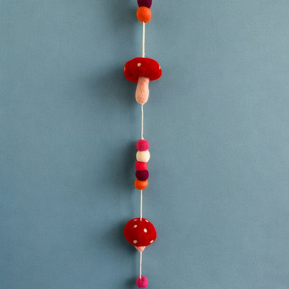Alt Tag: Förtrollande väggbonad i filt – Redtop Mushrooms 110 CM med röda och vita filtsvampar och färgglada pom-poms på upphängningssnöre