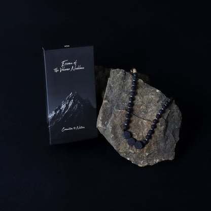 Alt Tag: Essence of the Volcano-halsband – koppling till naturen lavapärlehalsband visat på vulkanisk sten med märkt box