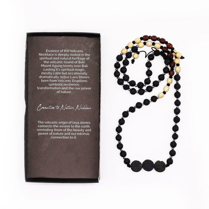 Alt Tag: Essence of the Volcano Necklace – Kontakt med naturen med naturliga lavastenpärlor, svarta och beige accenter, visas bredvid produktboxen