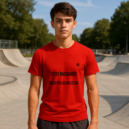 Estoy Madurando Adolecente Sustainable Unisex Tee roja con texto “ESTOY MADURANDO, DISCULPEN LAS MOLESTIAS”, modelo en skatepark