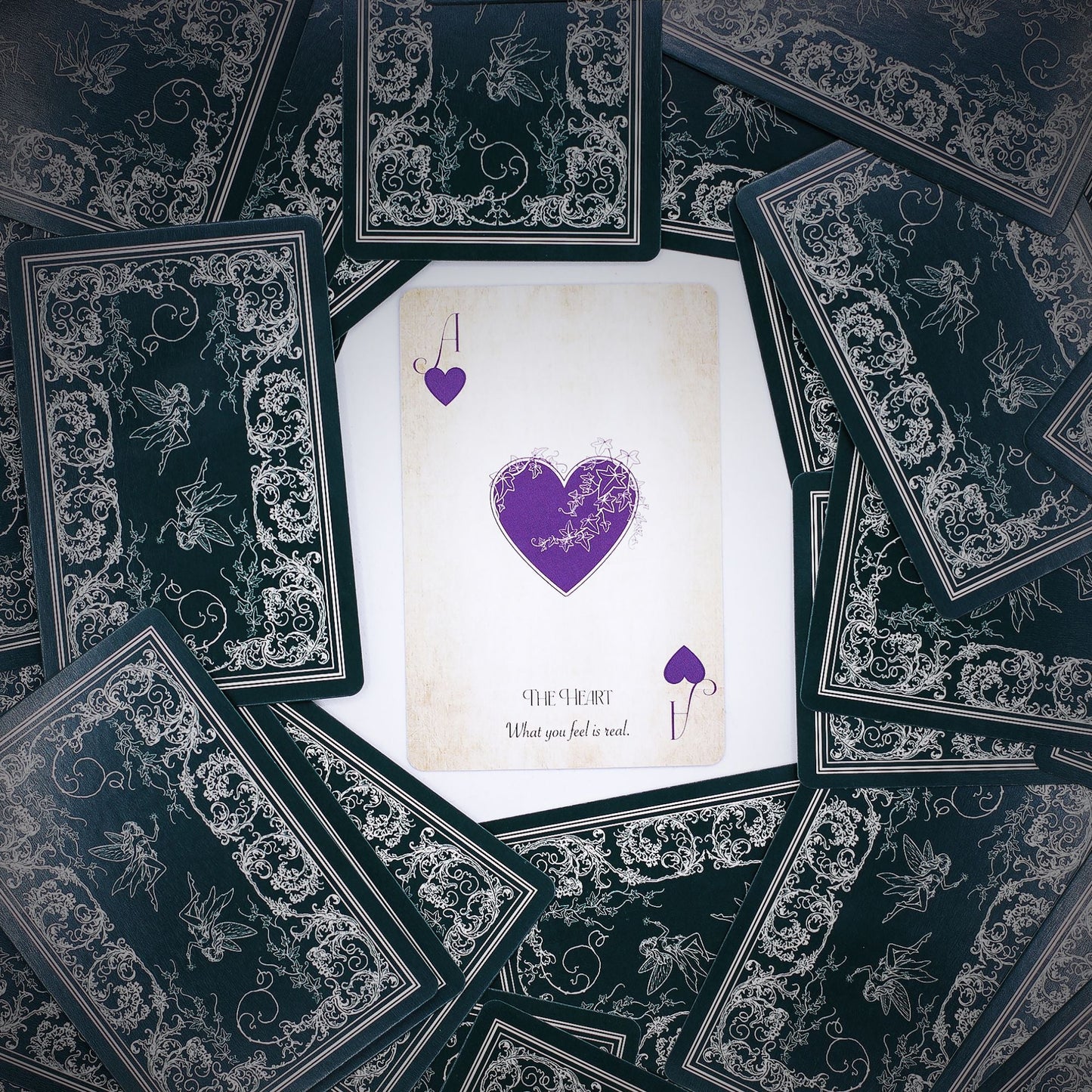 Alt Tag: Fae Realm Oracle Cards – 54-Card Deck spread with ornate black backs and central heart card, fairy-themed premium oracle deck