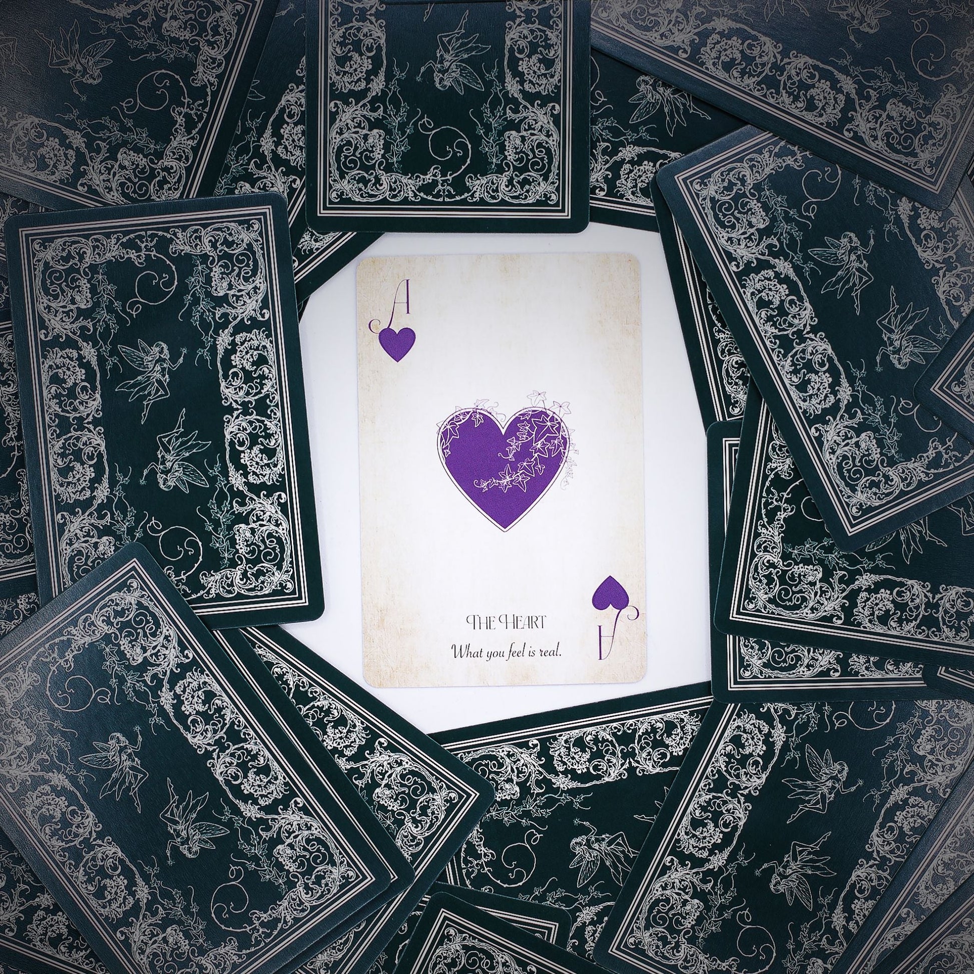 Alt Tag: Fae Realm Oracle Cards – 54-Card Deck spread with ornate black backs and central heart card, fairy-themed premium oracle deck