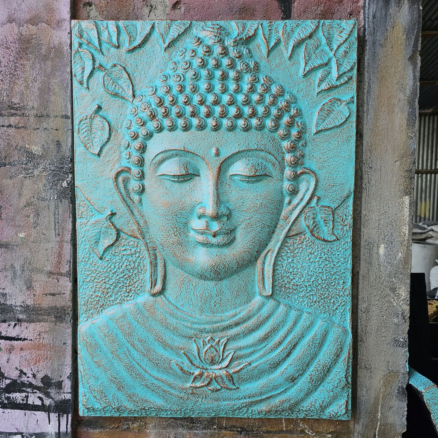 Alt Tag: Fibre Cement Buddha Relief – 0.7x1M, panel turquesa con rostro de Buda en relieve y marco de hierro, arte mural decorativo