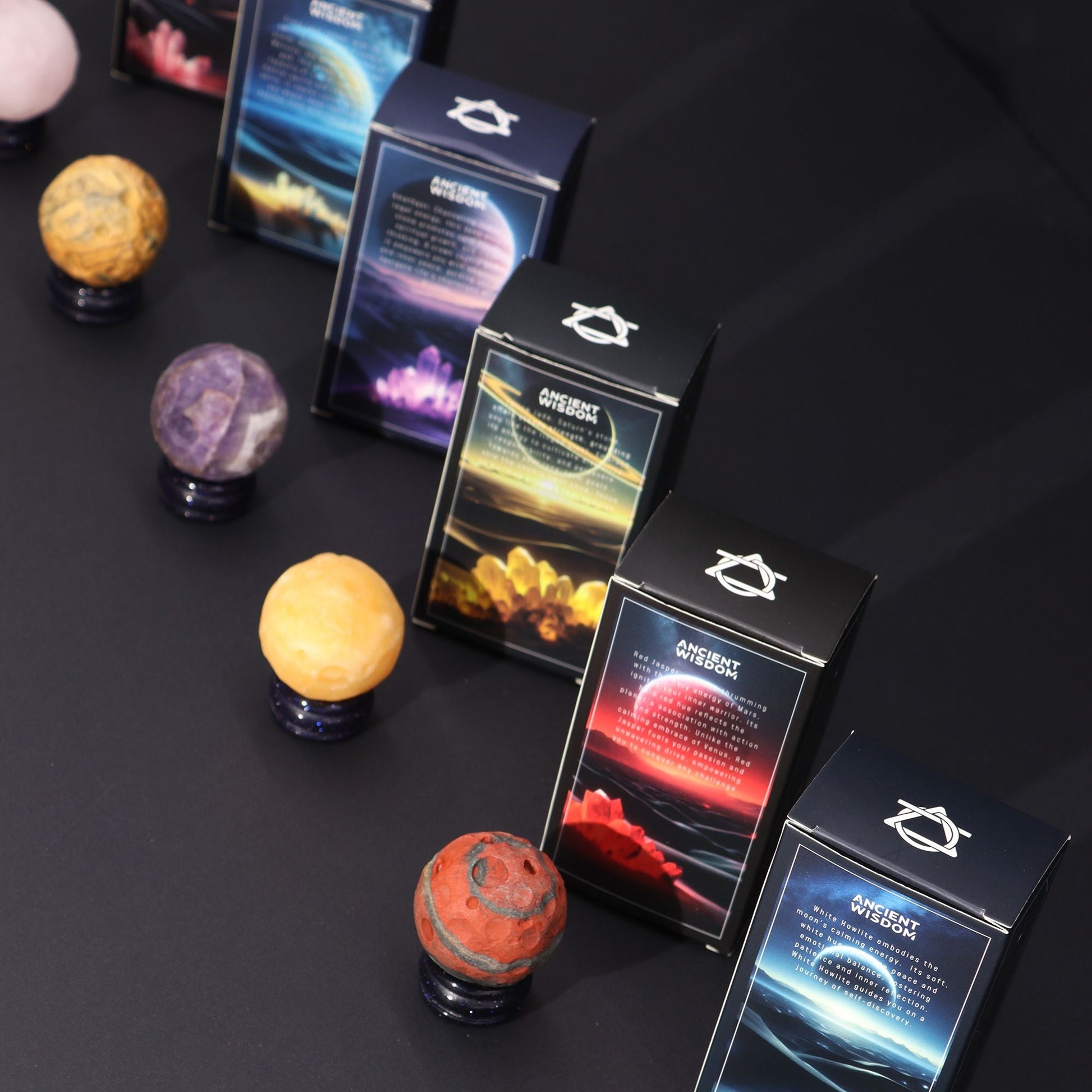 Rose Quartz Gemstone Planet – 40MM with Goldstone Stand product boxes and gemstone spheres displayed on black surface