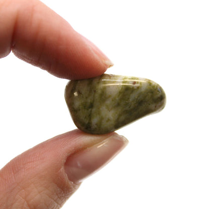 Alt Tag: Gemstone Tumble Stones – Set of 24, piedra pulida verde jaspeada sostenida entre los dedos, detalle de textura y brillo