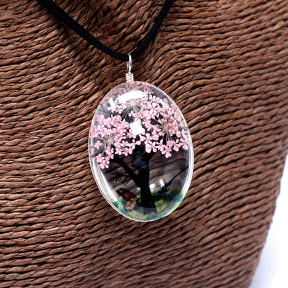 Alt Tag: Glass & Flowers Jewelry – Tree of Life, Pink pendant necklace with pressed pink flowers in glass oval charm on black cord