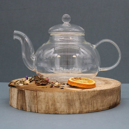 Alt Tag: Glass Infuser Teapot – Round Pearl – 800 ML de vidrio borosilicato con infusor, tetera redonda transparente sobre base de madera