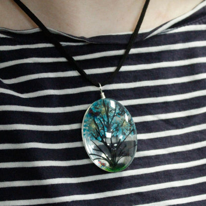 Alt Tag: Glass & Flower Tree of Life Jewellery – Green pendant necklace with pressed flowers encased in glass, worn on striped top