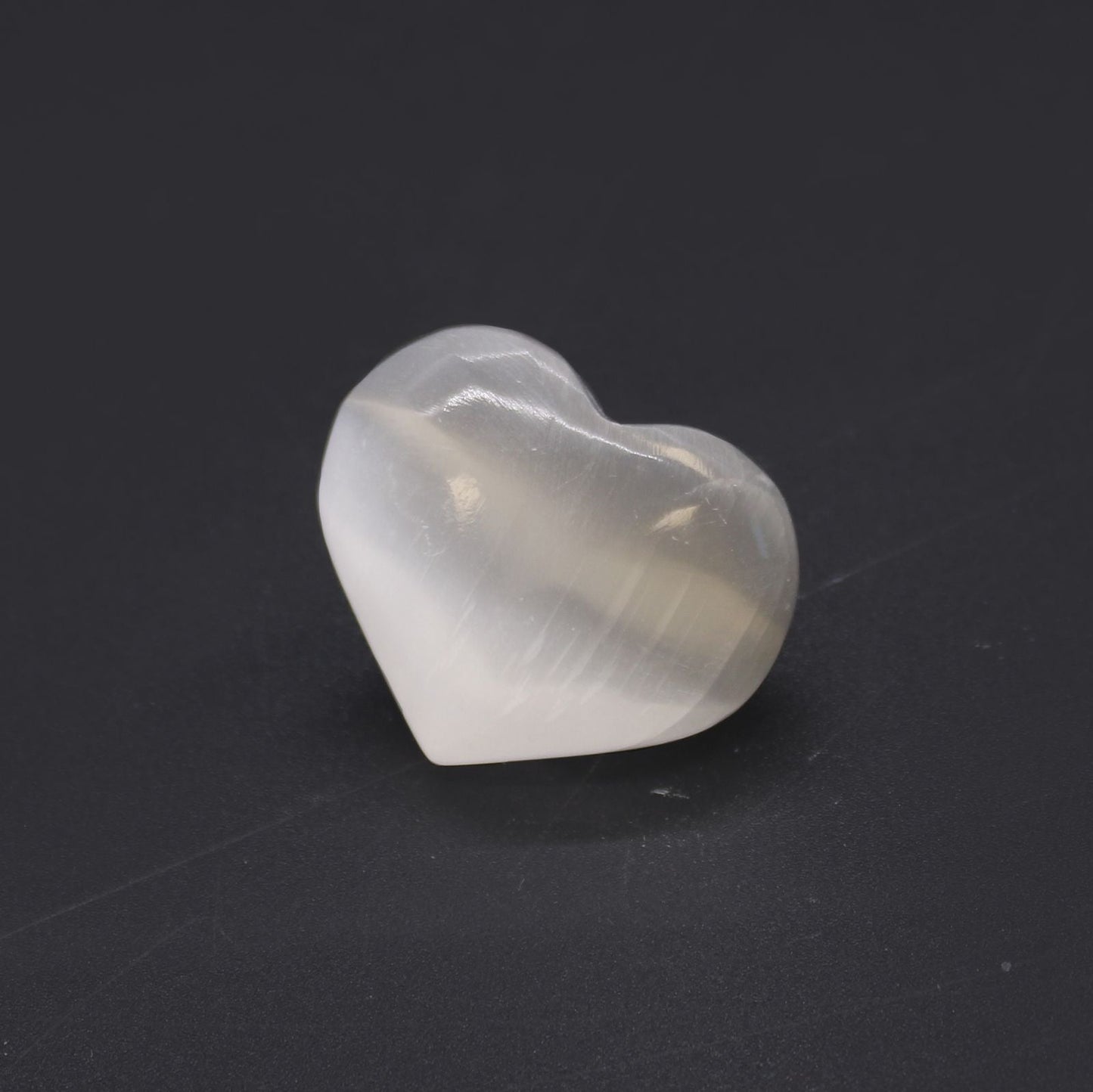 Glowing Selenite Heart – 3-4 CM heart-shaped selenite crystal from Morocco, smooth polished finish on dark background