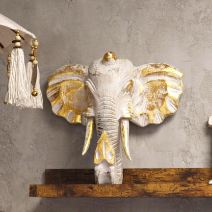 Cabeza de elefante Gold & Whitewash – decoración de pared 29x26 CM en madera de Albasia con detalles dorados y acabado whitewash, montada en pared gris