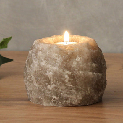 Alt Tag: Grey Himalayan Salt Candle Holder – 600-800G grey natural Himalayan salt tealight holder with lit candle on wooden table