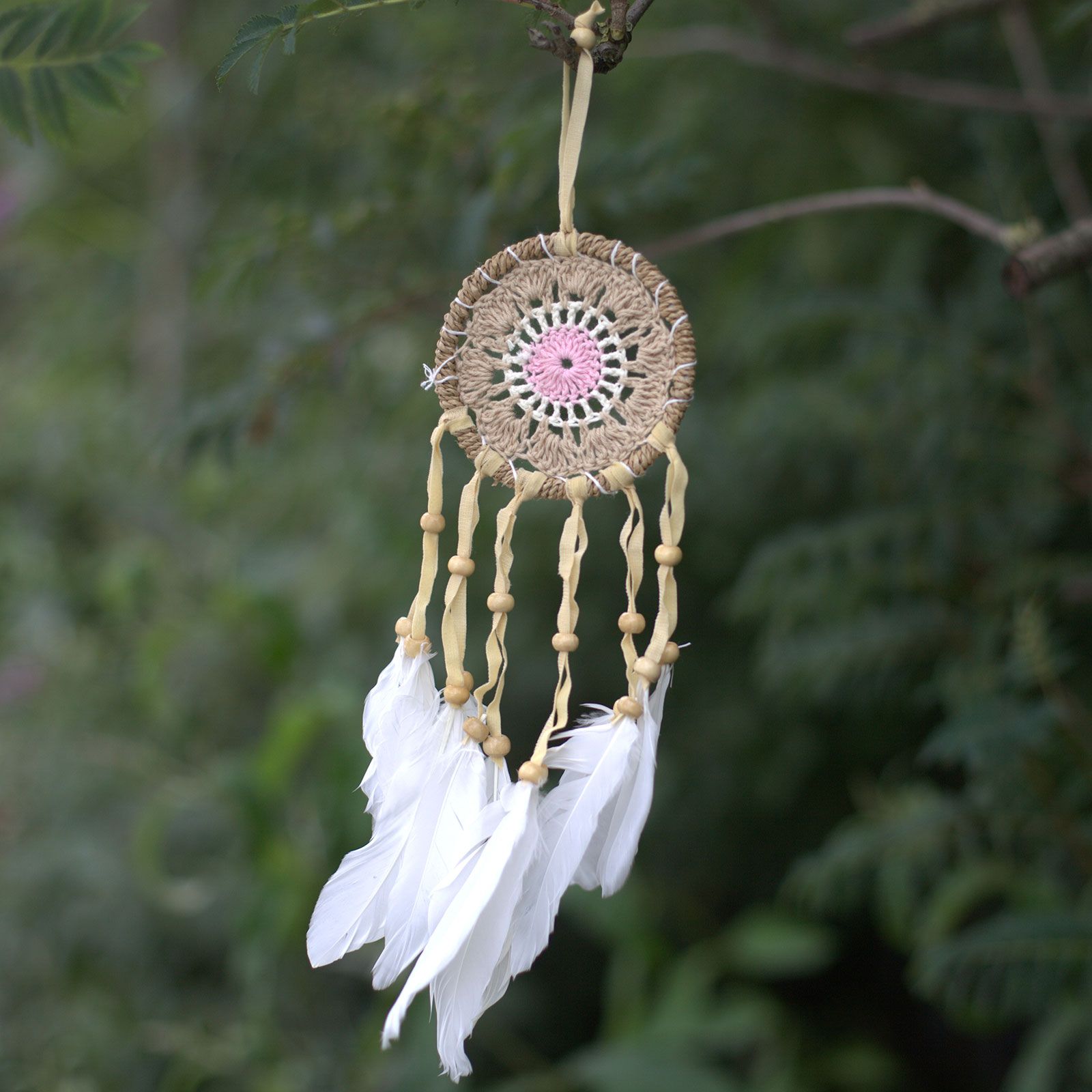 Cotton Pastel Dream Catcher – 9CM handmade pastel pink cotton dream catcher with white feathers hanging outdoors