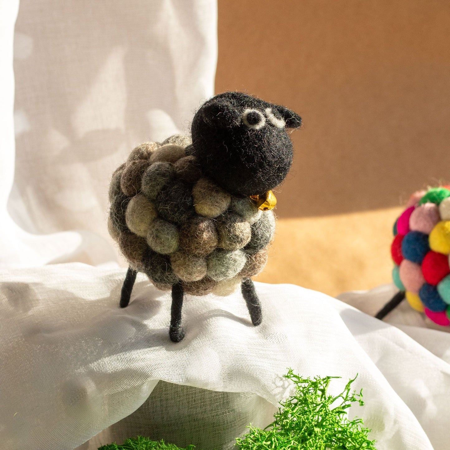 Alt Tag: Handcrafted Felt Sheep Figurine – Multi Greys, felt sheep decor with metal legs, multi grey wool body on fabric backdrop