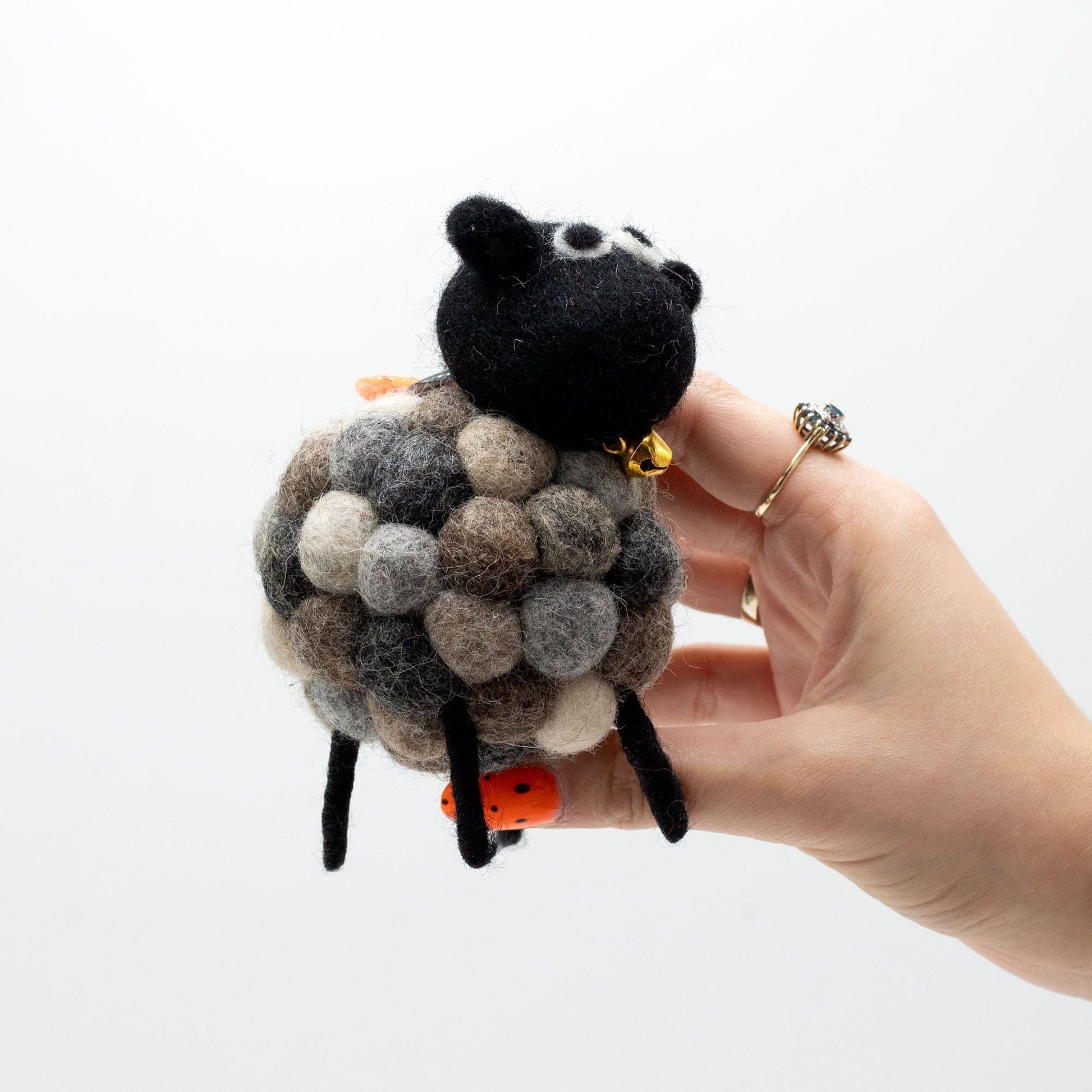Alt Tag: Handcrafted Felt Sheep Figurine – Multi Greys, handmade multi-grey felt sheep decor with black head, held in hand on white background
