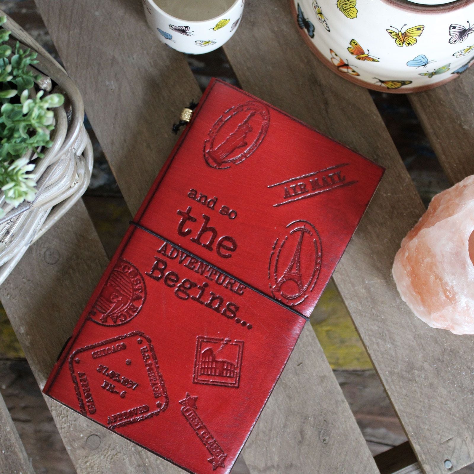Alt Tag: Handcrafted Leather Journal – Red, 80 Pages, red embossed leather notebook with wrap cord and recycled paper pages on wooden table